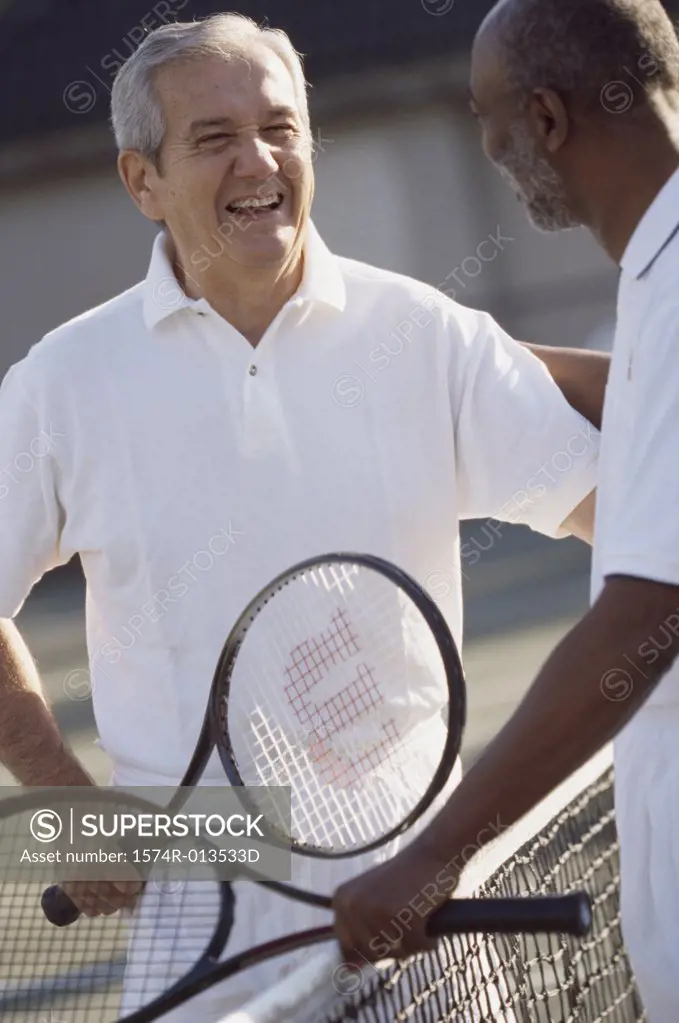 Two senior men standing on a tennis court