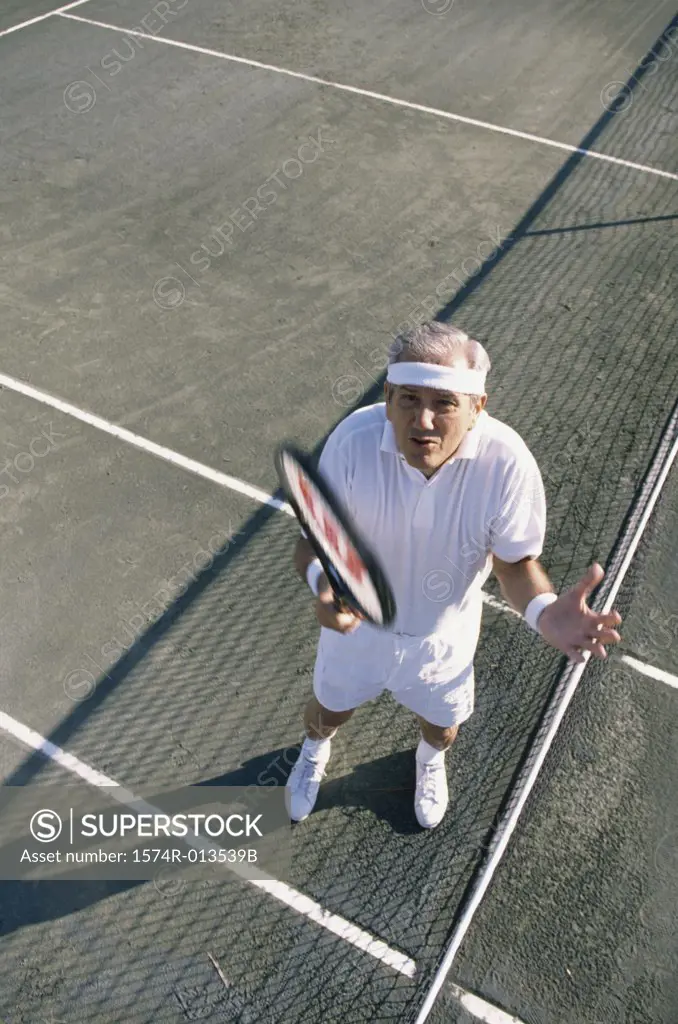 High angle view of a senior man gesturing on a tennis court