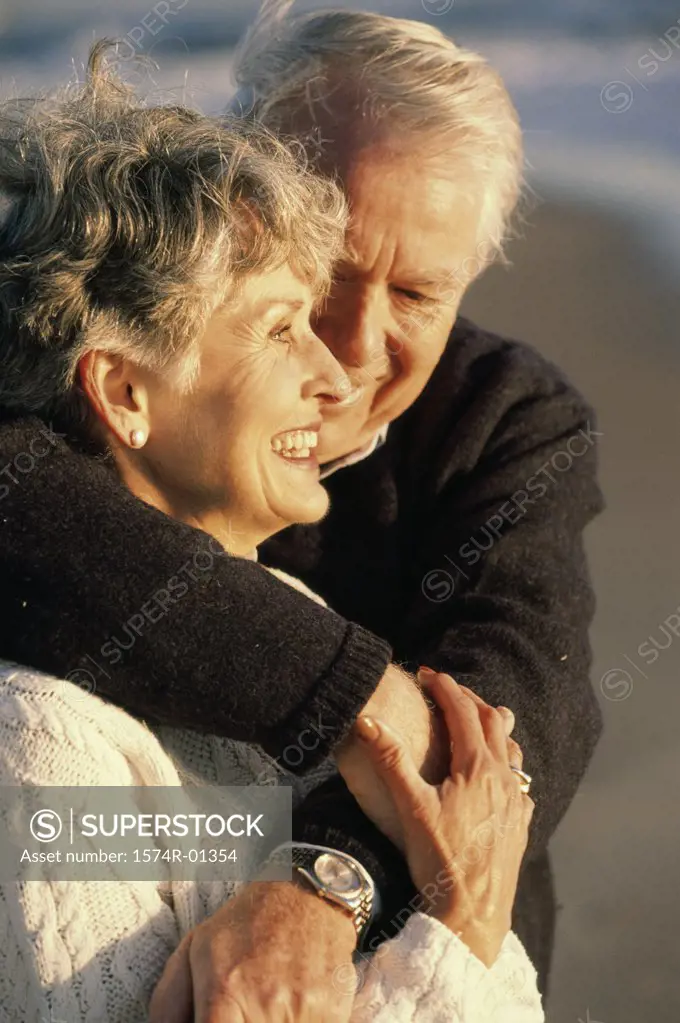 Close-up of a senior couple holding each other at the beach