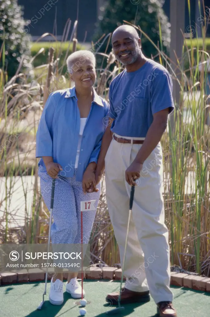 Senior couple standing on a miniature golf course