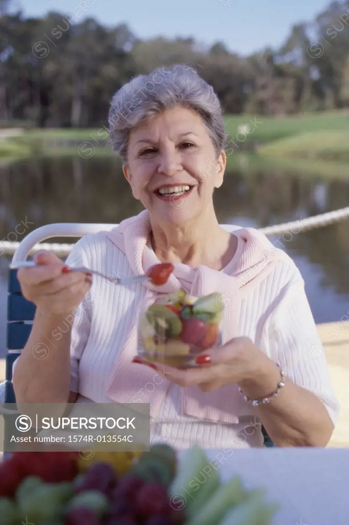 Portrait of a mature woman eating fruit salad