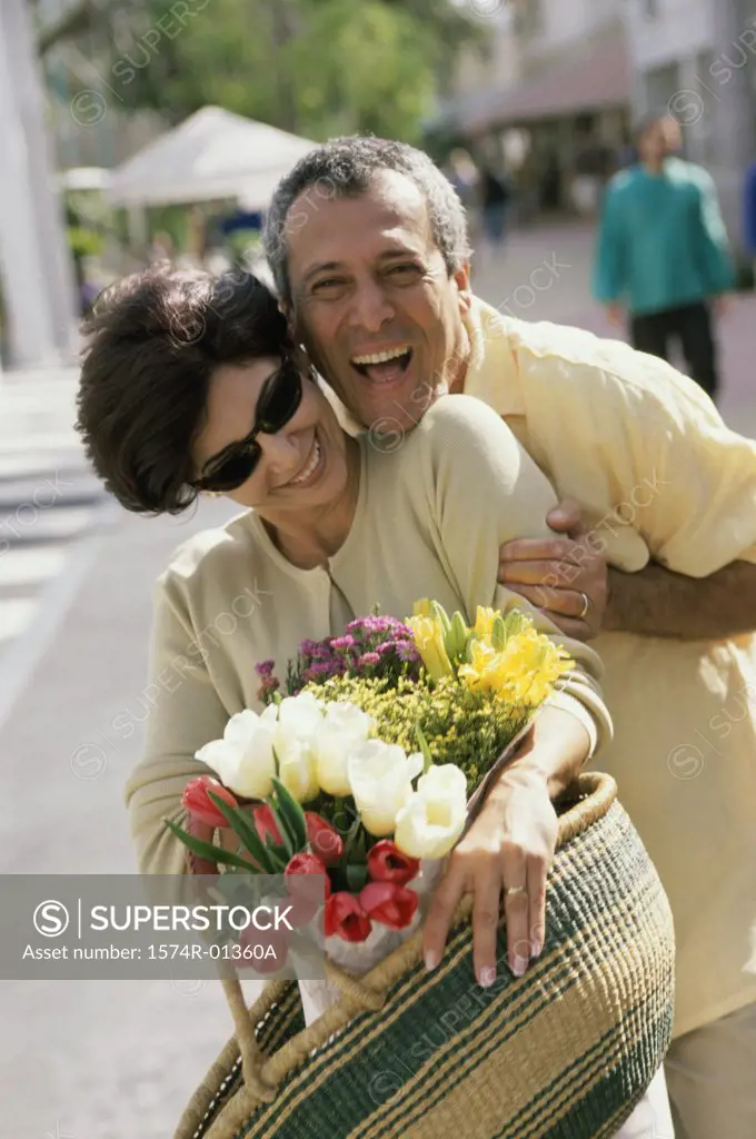 Portrait of a couple smiling holding a bouquet of flowers