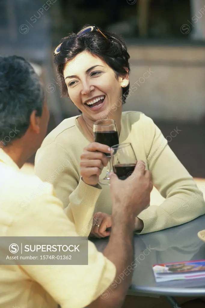 Couple sitting together toasting with red wine