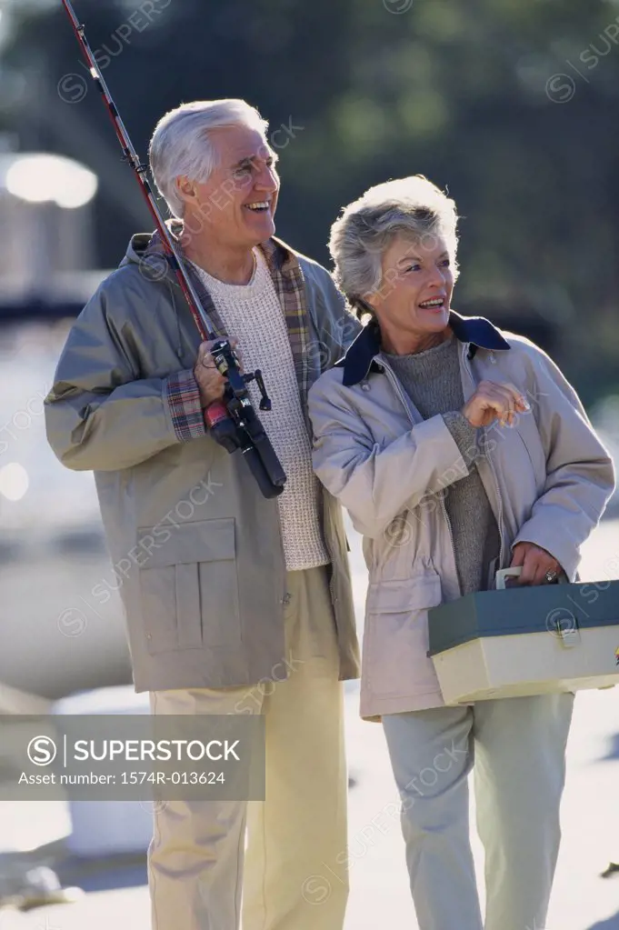 Senior couple holding a fishing rod and a box