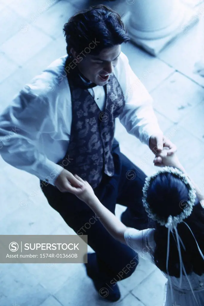 High angle view of a groom dancing with a flower girl