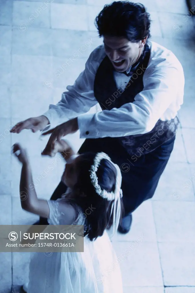High angle view of a groom dancing with a flower girl