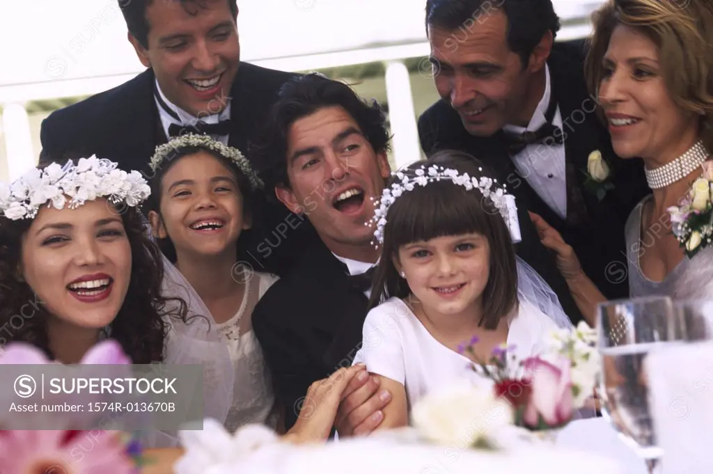 Newlywed couple sitting with wedding guests