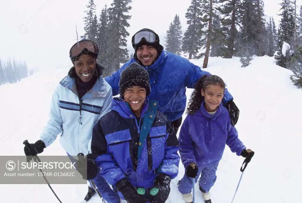 Portrait of parents standing with their two children in snow