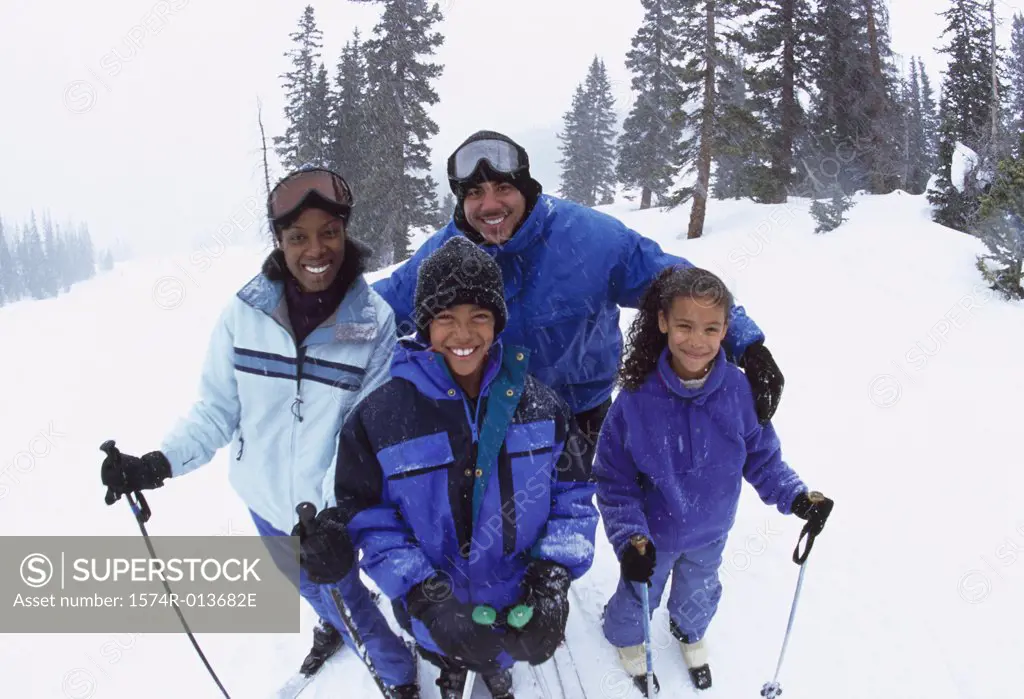 Portrait of parents standing with their two children in snow