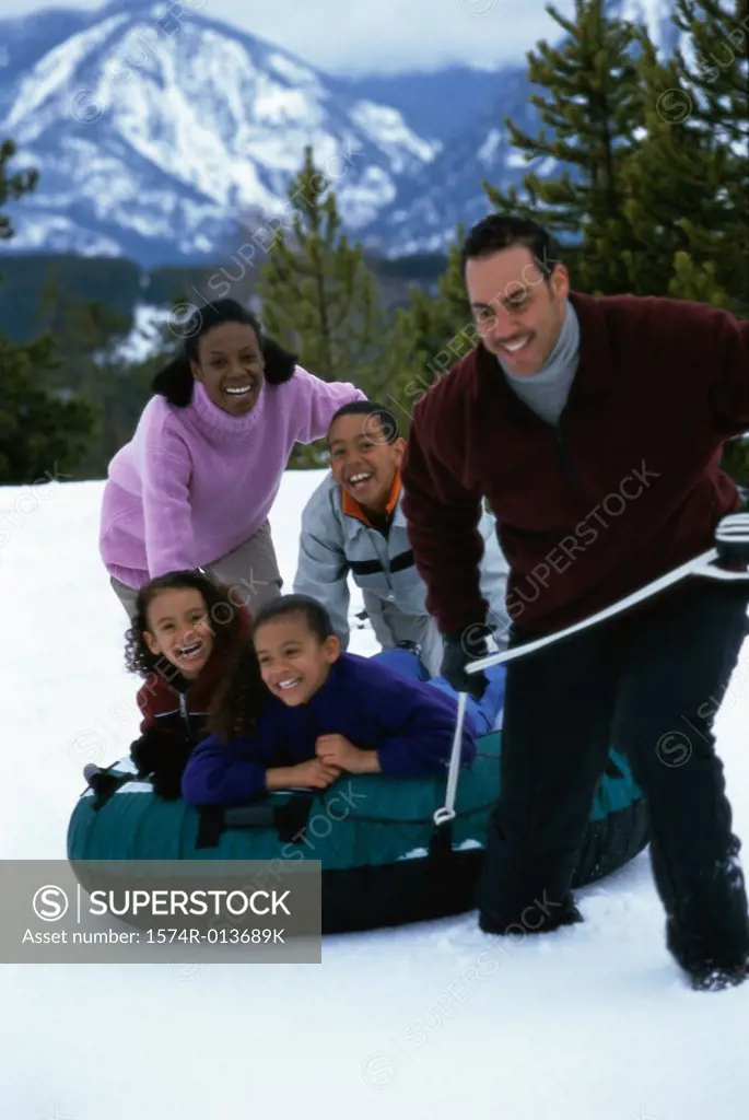 Parents playing with their three children in snow