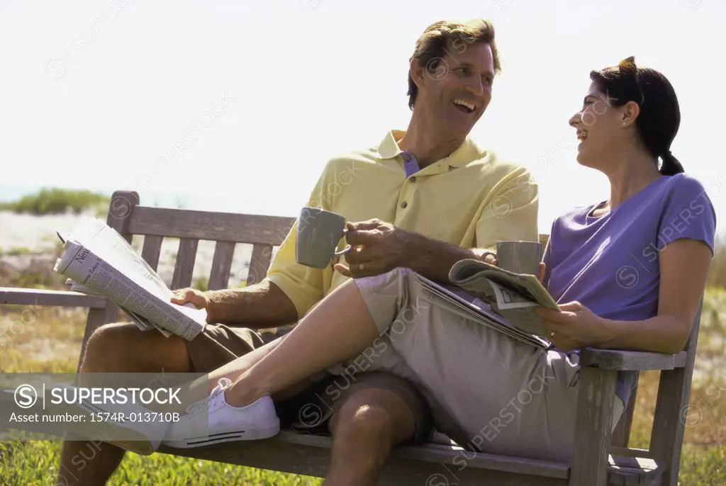 Mid adult couple sitting on a bench and laughing