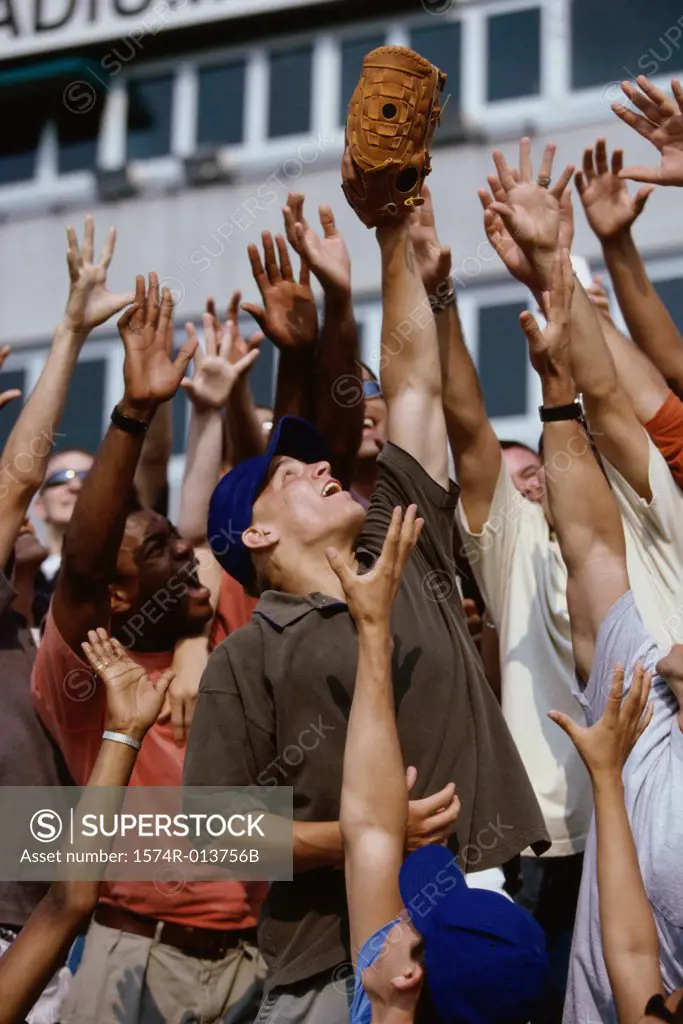 Group of people reaching up for a baseball