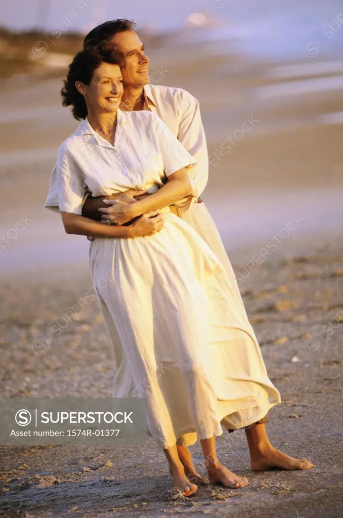 Couple holding each other standing on the beach