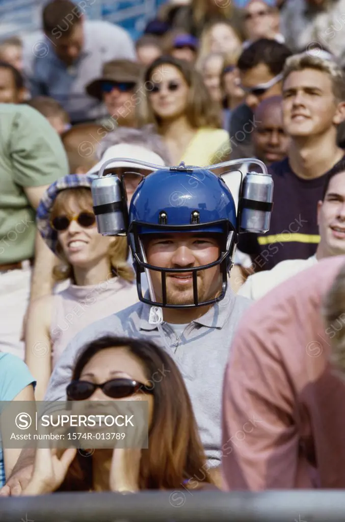 Portrait of a spectator wearing a football helmet