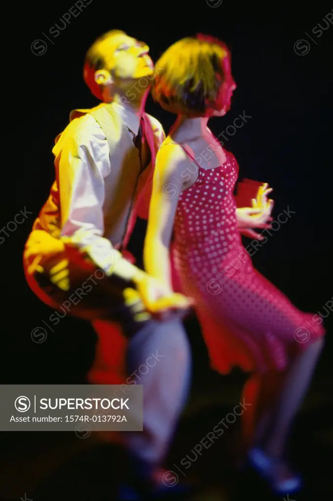 Side profile of a young couple swing dancing