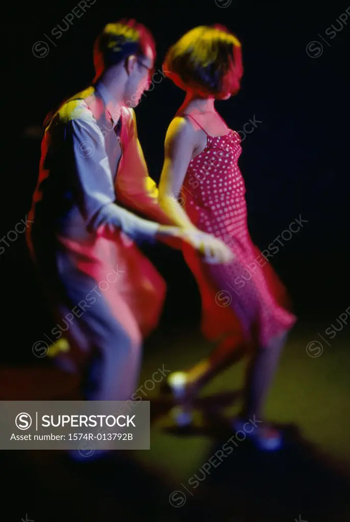Side profile of a young couple swing dancing
