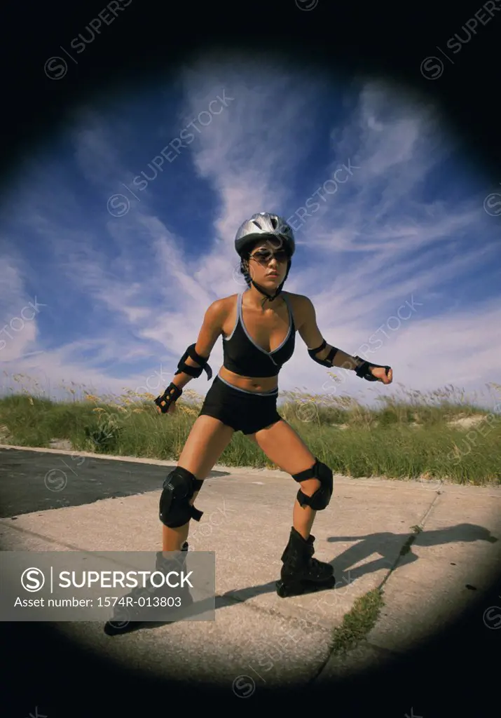 Young woman inline skating on a road