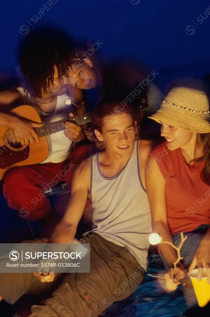Two young couples on the beach at night