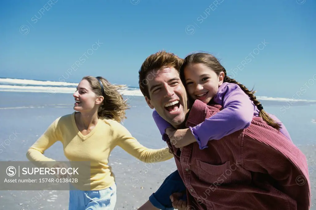 Parents playing with their daughter on the beach