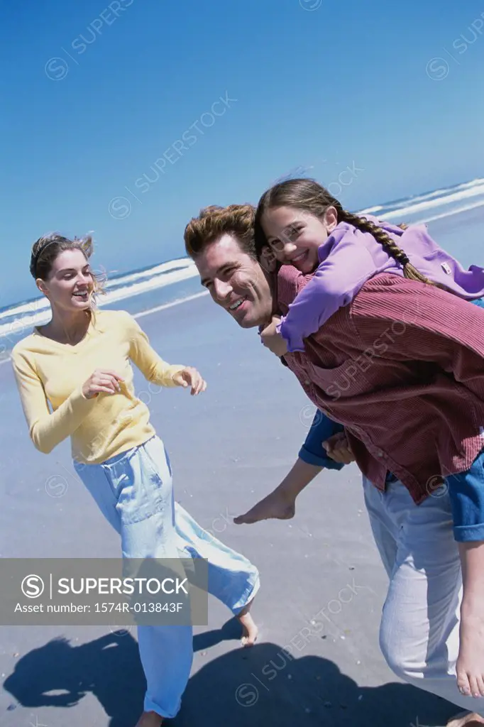 Parents playing with their daughter on the beach