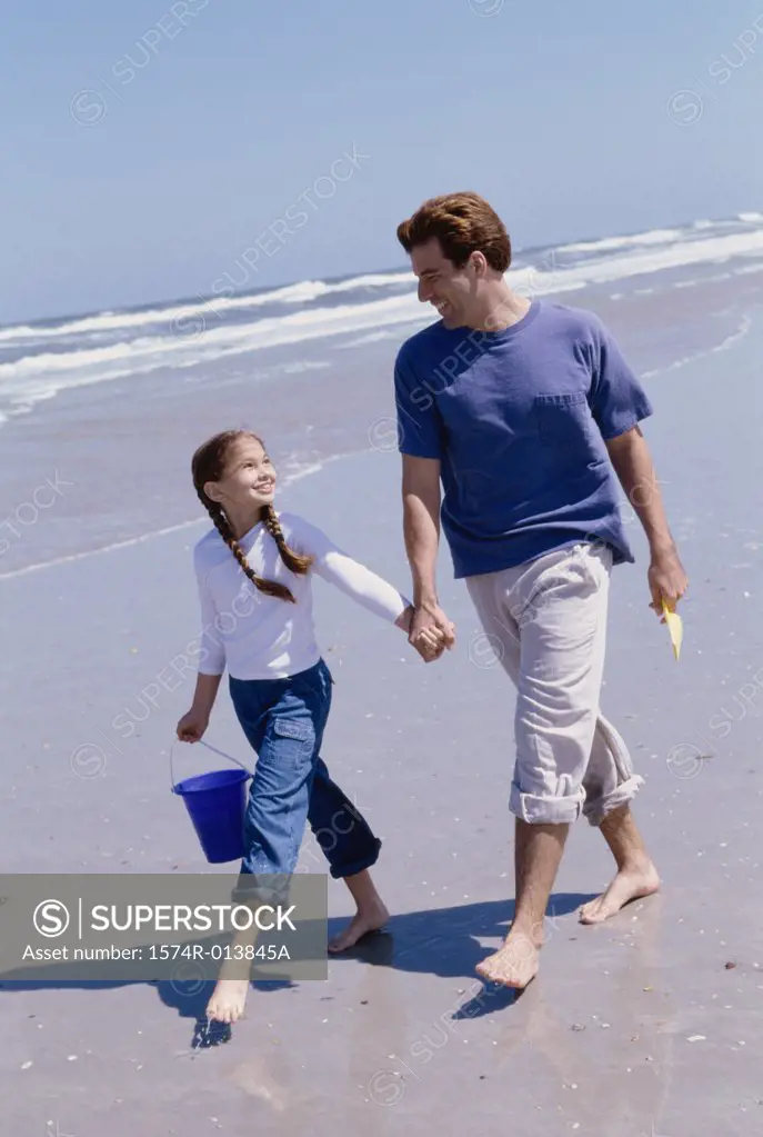Father and daughter walking on the beach