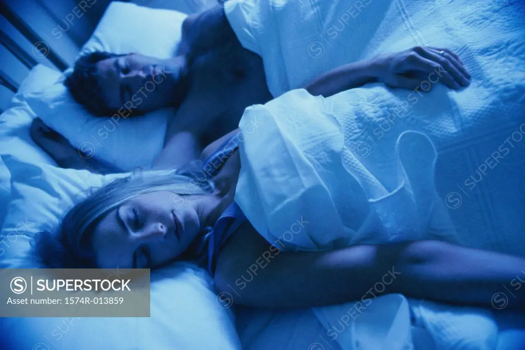 High angle view of a young couple sleeping in bed