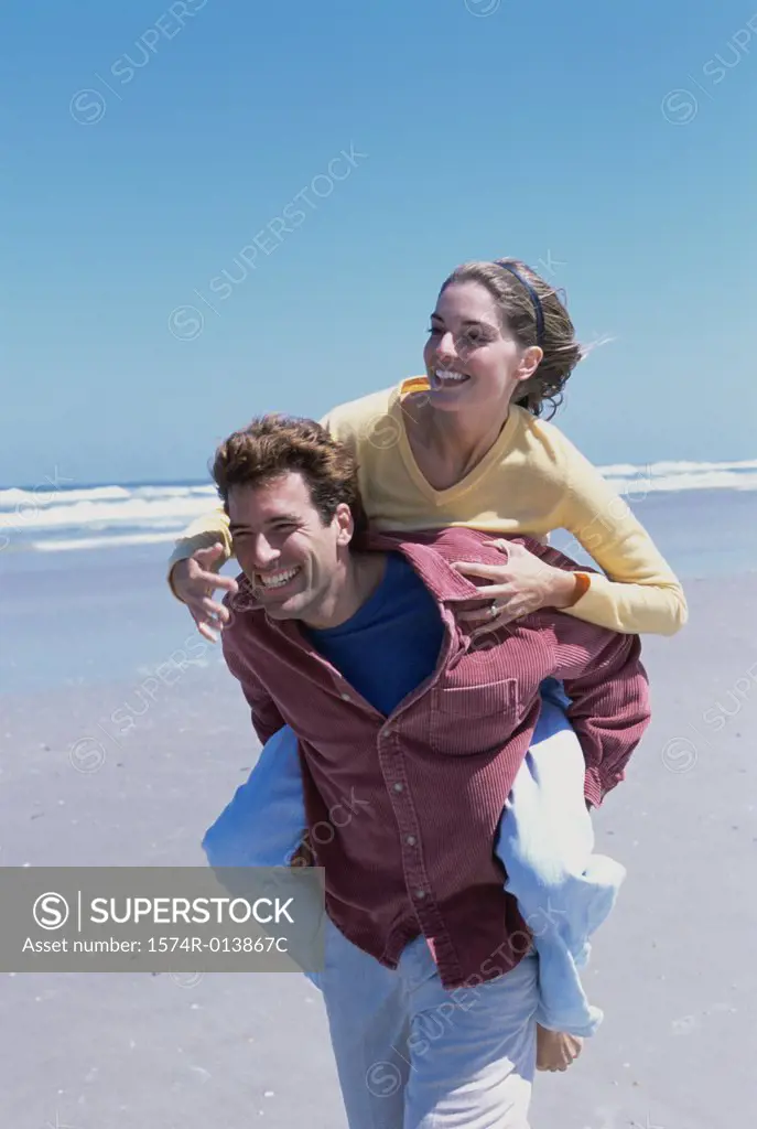 Young woman riding piggyback on a young man