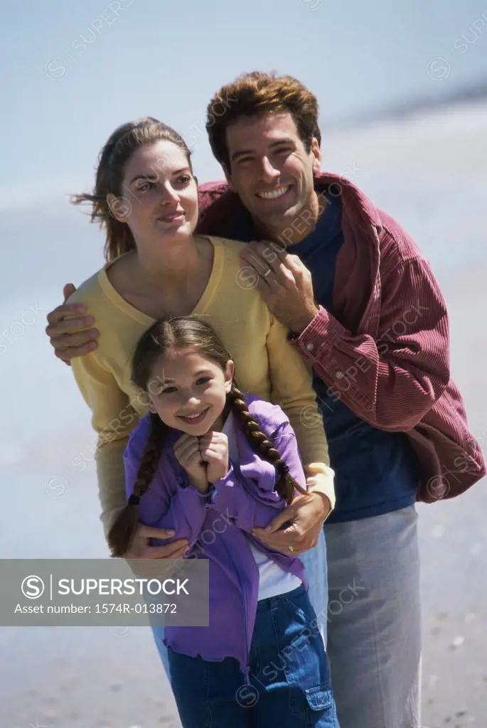 Parents and their daughter standing on the beach