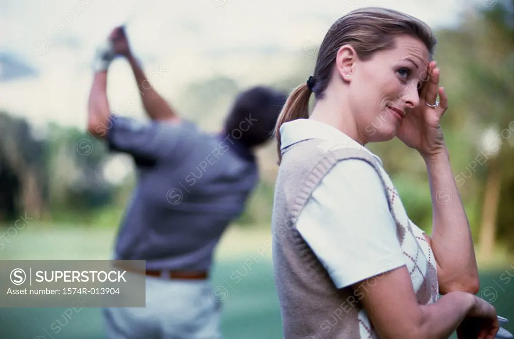 Side profile of a young woman standing on a golf course