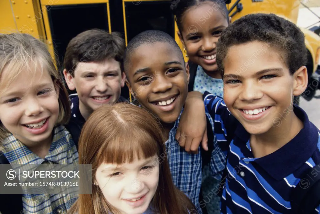 Portrait of children near a school bus