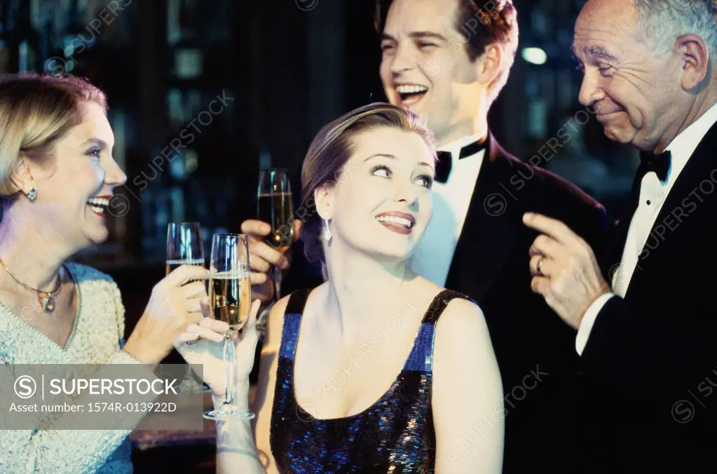 Close-up of a young couple and a senior couple holding wineglasses in a nightclub
