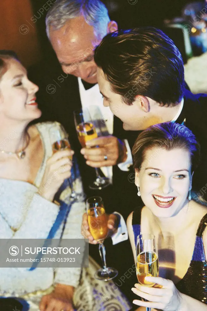 High angle view of a young couple and senior couple holding glasses of champagne at a bar