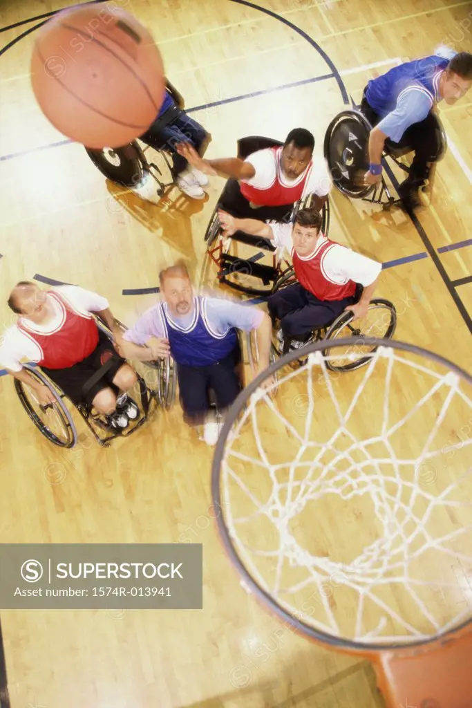 High angle view of a group of mid adult men in wheelchairs playing basketball