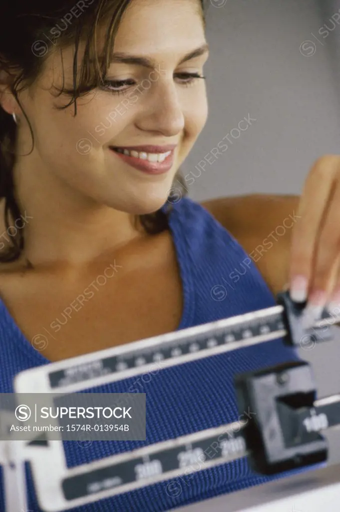 Close-up of a young woman adjusting a weight scale