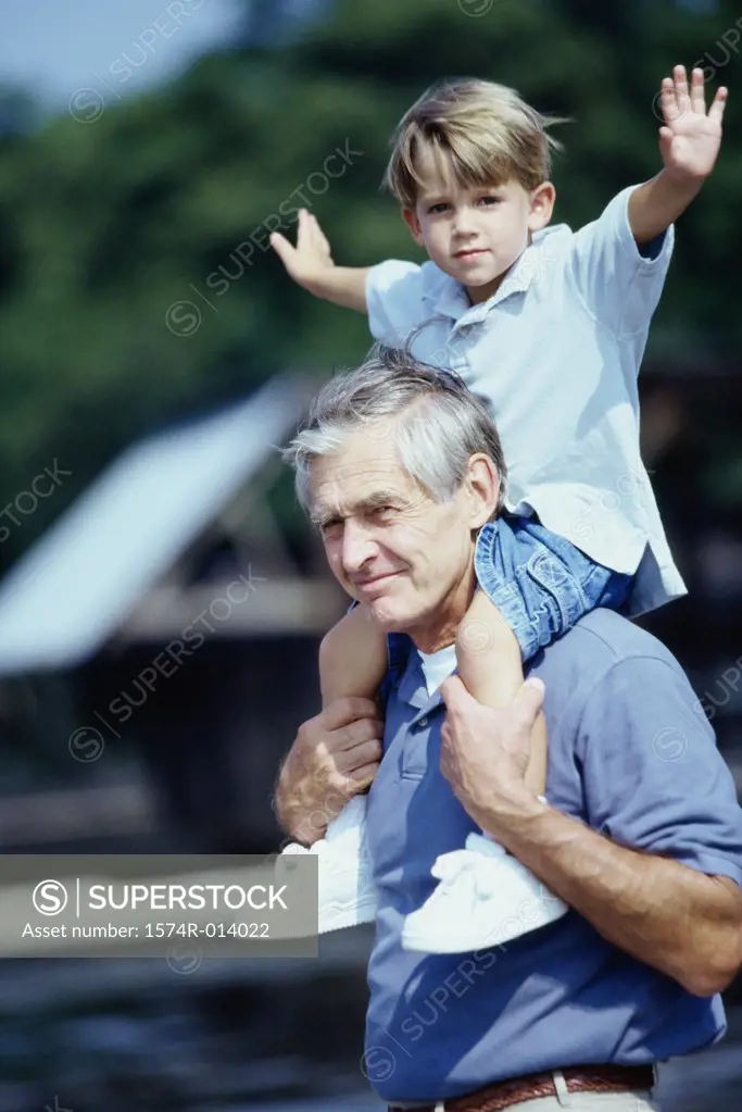 Side profile of a grandfather carrying his grandson on his shoulders