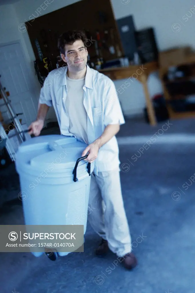 High angle view of a young man carrying a trash can