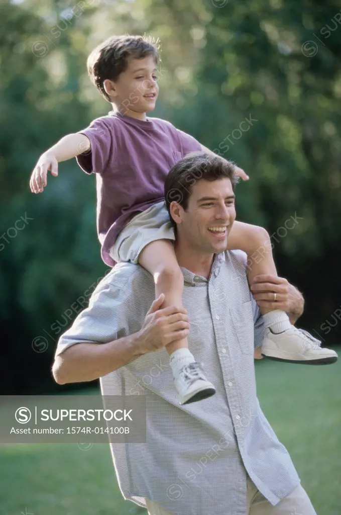 Close-up of a father carrying his son on his shoulders