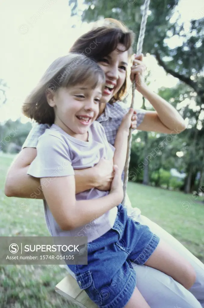 Mother and daughter swinging on a swing