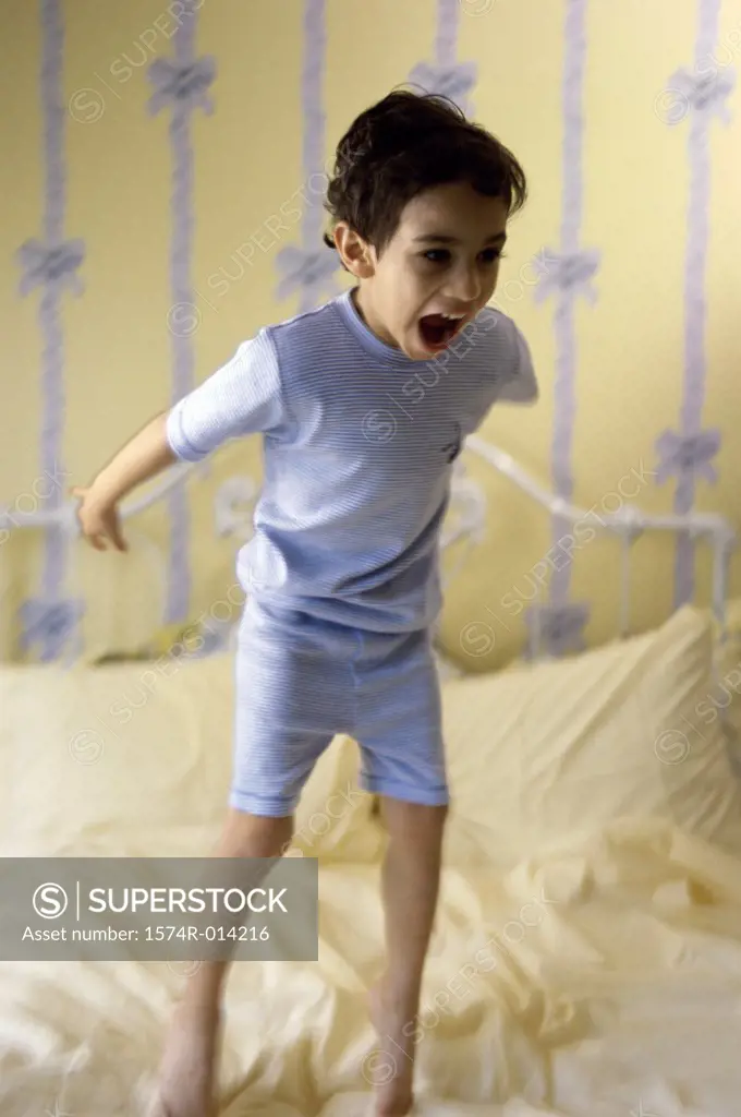 Boy jumping on a bed