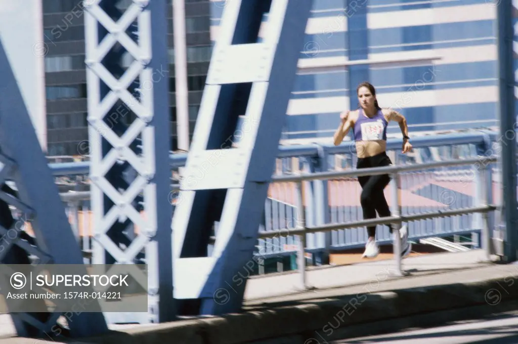 Young woman running on a bridge