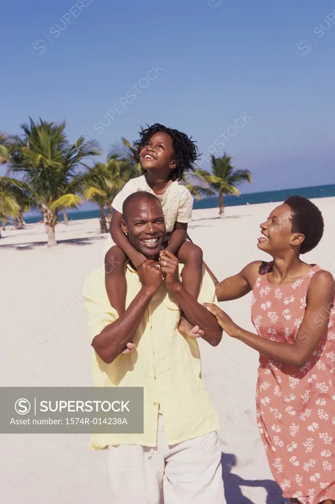 Parents and their daughter walking on the beach
