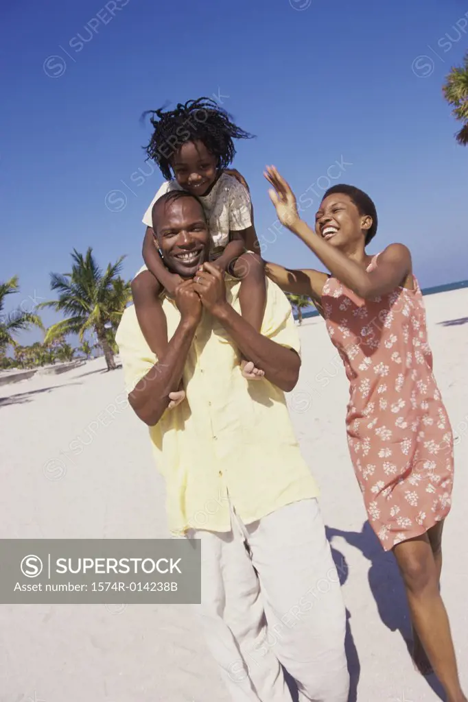 Parents and their daughter walking on the beach
