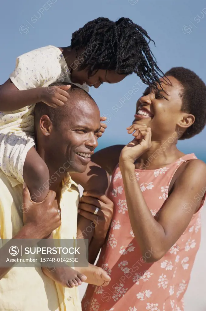 Parents and their daughter smiling on the beach