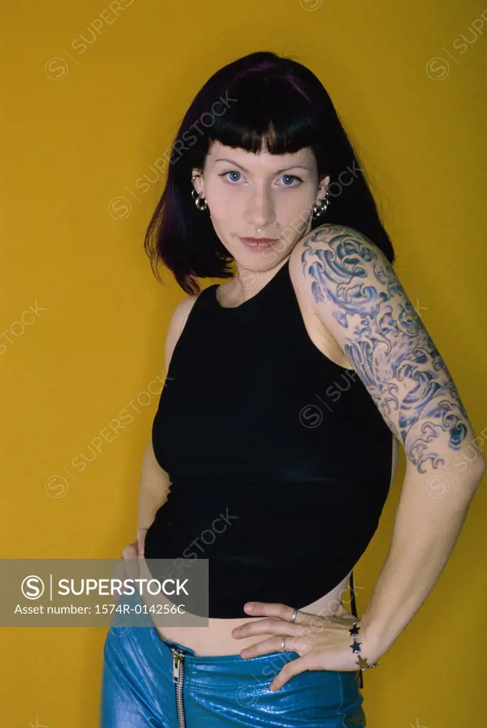 Portrait of a young woman with tattoos on her arms