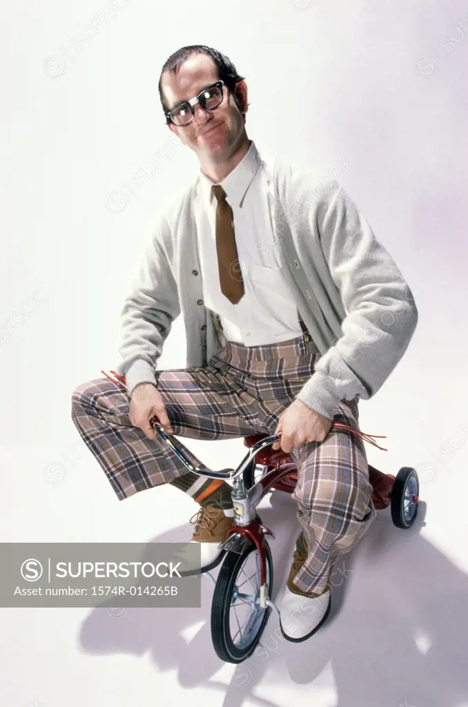 Portrait of a young man riding a tricycle