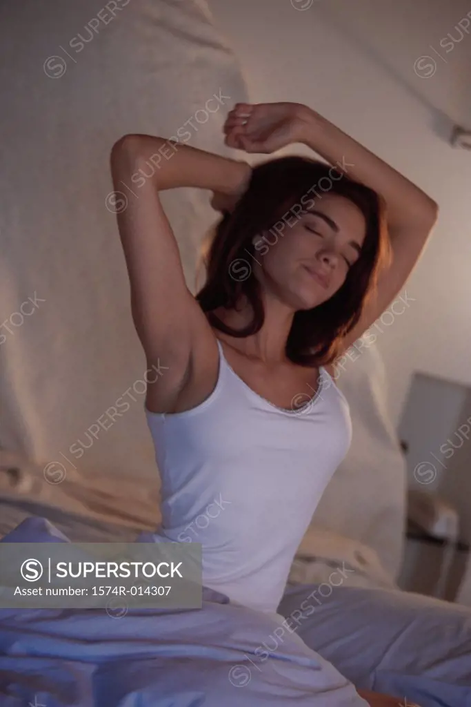 Young woman stretching in bed
