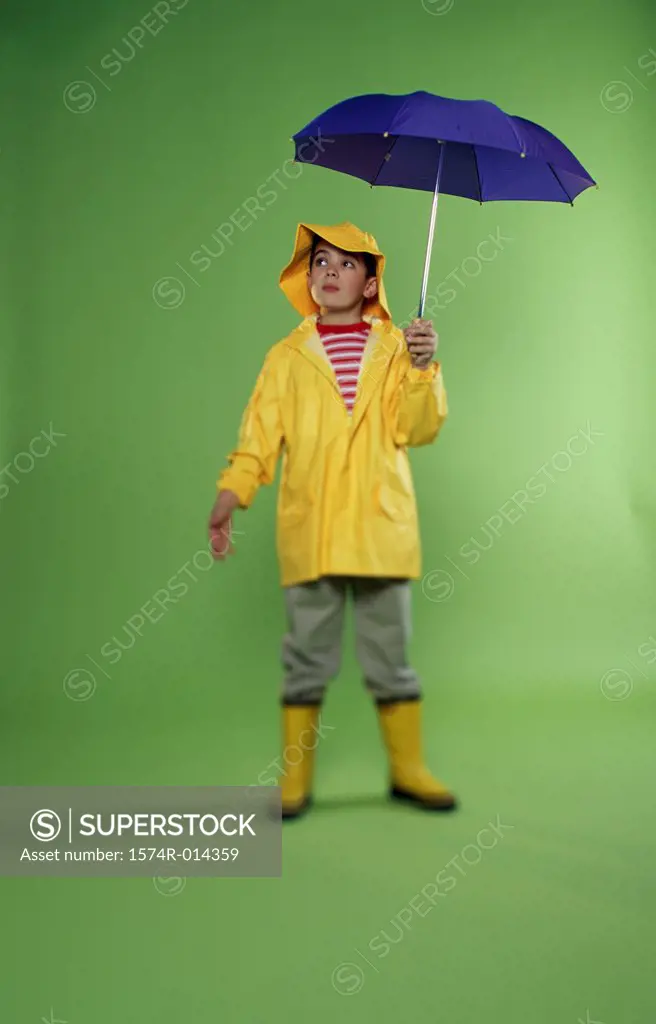 Boy wearing a raincoat and holding an umbrella