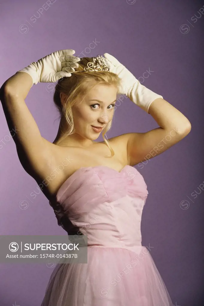 Portrait of a teenage girl holding a tiara