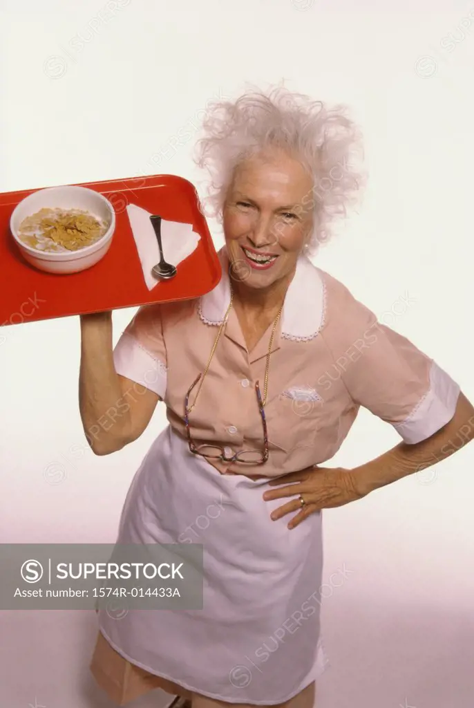 Portrait of a senior woman carrying a tray of food