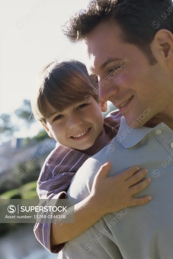 Close-up of a son hugging his father from behind